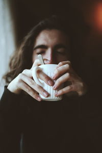 Close-up of young man holding coffee mug