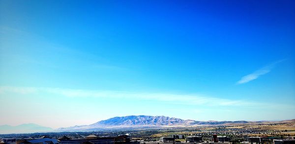 Scenic view of snowcapped mountains against blue sky