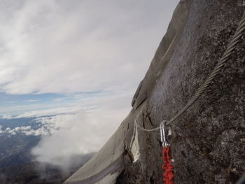 Close-up of rope on rock against sky