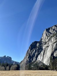 Scenic view of mountains against blue sky