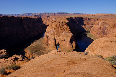 Full length of man on rock formation against sky