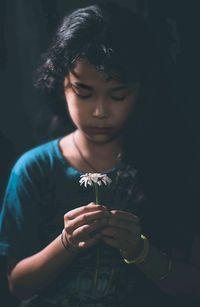 Close-up of cute girl holding flower