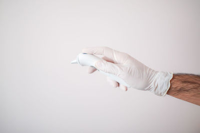 Close-up of hand holding hands over white background