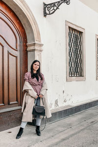 Portrait of woman sitting outside building