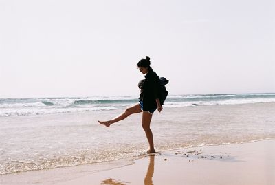 Full length of man on beach against clear sky