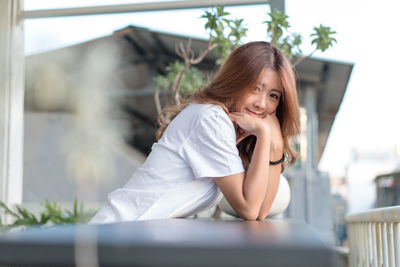 Portrait of smiling young woman at balcony