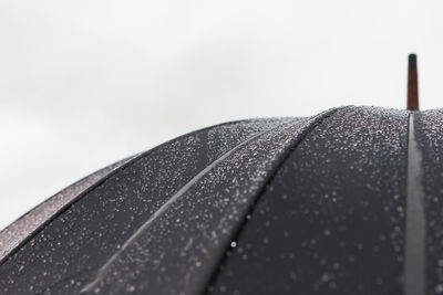 Close-up of raindrops on roof against sky