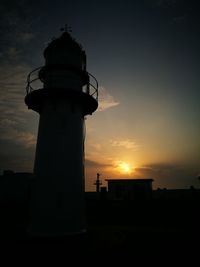 Low angle view of lighthouse against sky during sunset