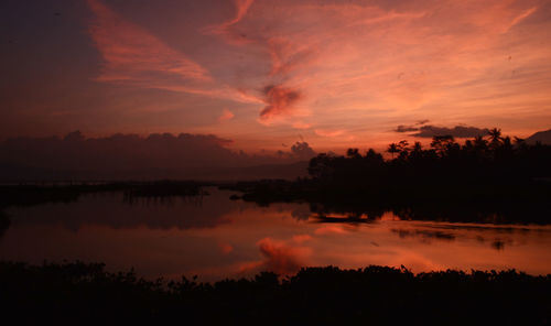 Scenic view of silhouette trees against romantic sky at sunset