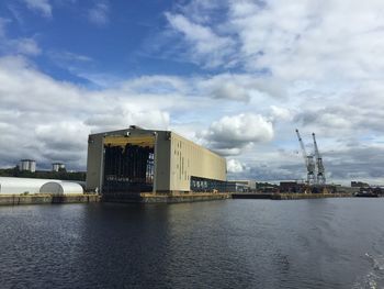 River in city against cloudy sky