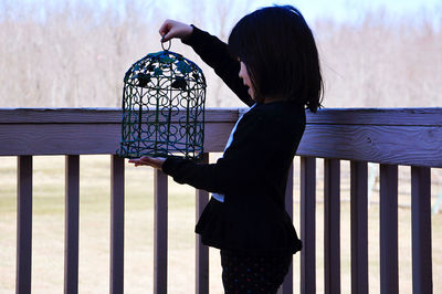 Girl holding bird cage