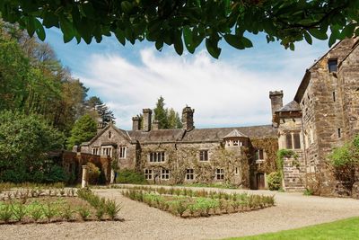 View of old house and trees against sky