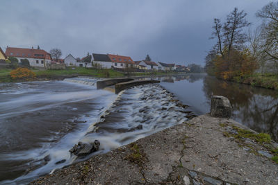 River amidst buildings against sky