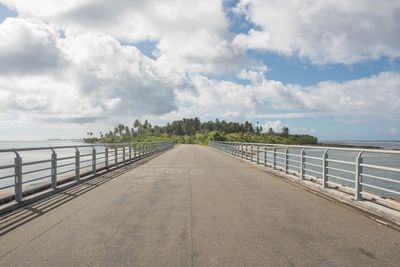 Road by railing against sky