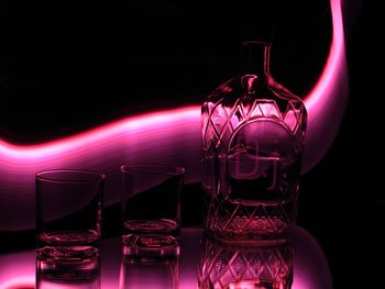 Close-up of illuminated bottle against black background