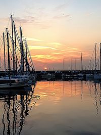 Sailboats in sea at sunset