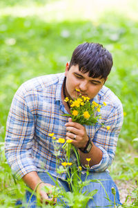 Midsection of man holding ice cream on field