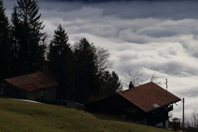 House amidst trees and buildings against sky