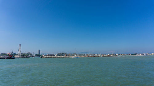 City by sea against clear blue sky