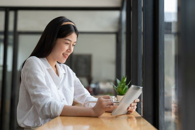 Young woman using mobile phone at home