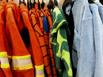 Midsection of multi colored clothes hanging on display at store