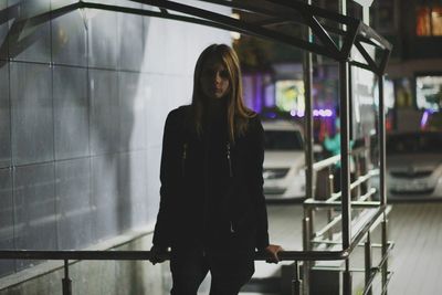 Portrait of woman standing by railing