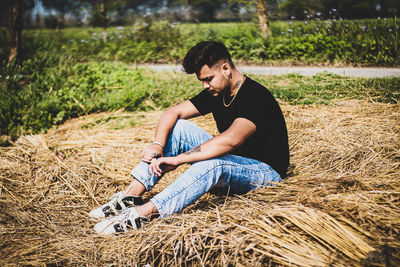 Young man sitting on field