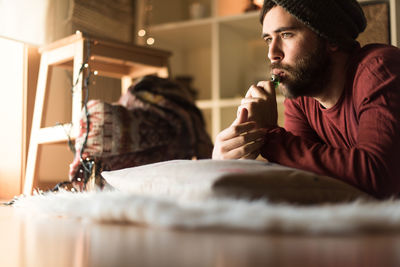 Young man looking away while smoking electronic cigarette