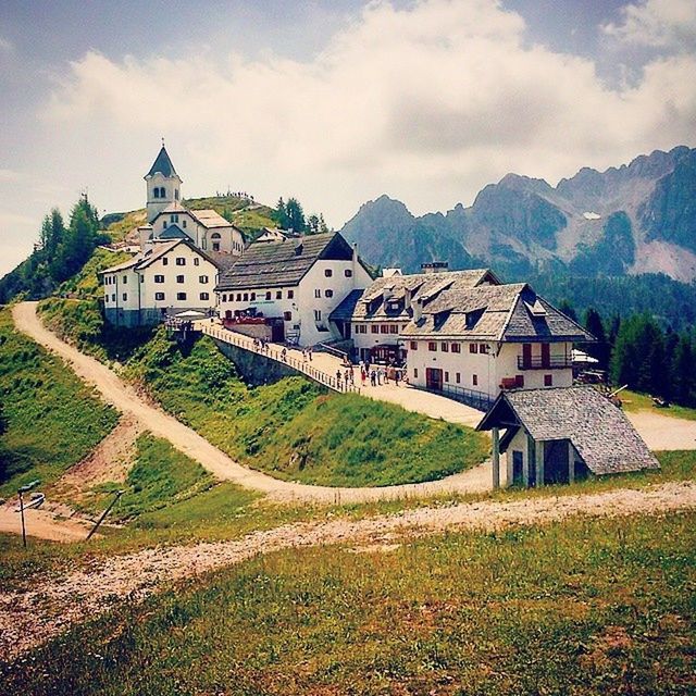 building exterior, architecture, built structure, sky, house, mountain, residential structure, cloud - sky, residential building, town, cloud, hill, tree, village, grass, landscape, church, townscape, day, cloudy