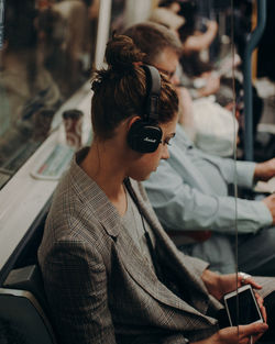 Portrait of woman using mobile phone while sitting in bus