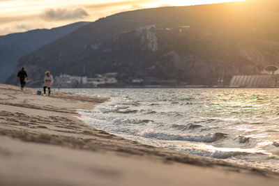People on beach against sky