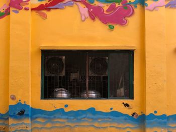 Close-up of yellow glass window of building