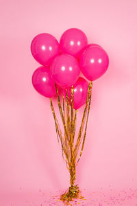 Festive fuchsia or pink balloons with gold threads, collected in a bouquet for a birthday
