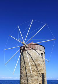 Low angle view of traditional windmill against blue sky