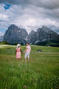 Rear view of women on field against sky