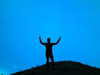 Full length of man standing against blue sky