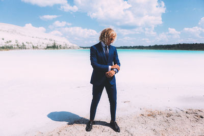 Full length of man standing on beach against sky