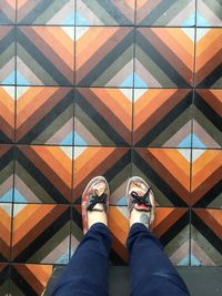 Low section of person standing on tiled floor