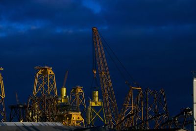 Low angle view of crane against blue sky