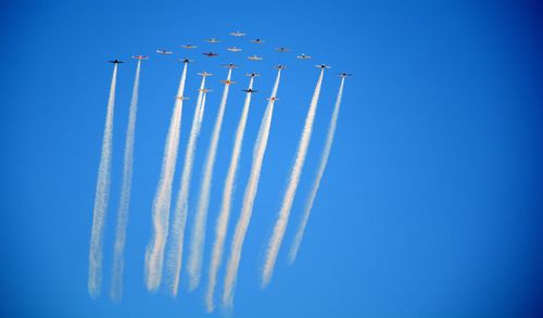 Low angle view of airplane flying against clear blue sky