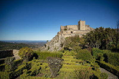 Low angle view of old ruins against clear blue sky