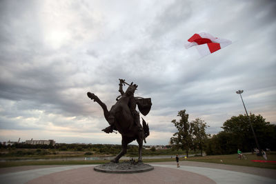 Statue of angel against cloudy sky