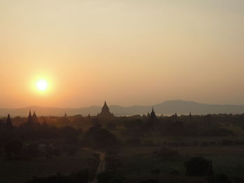 Silhouette temple against sky during sunrise