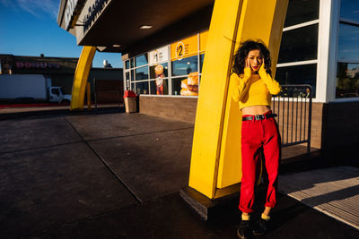 Full length portrait of woman standing on street