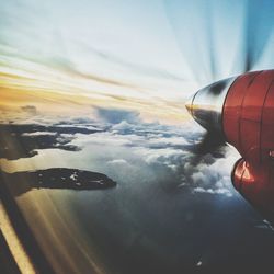 Airplane flying over sea against sky