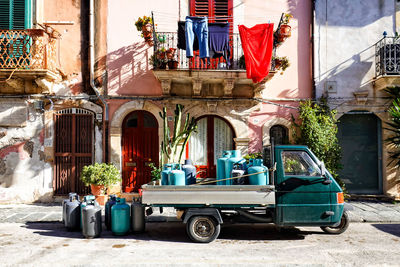 Small italian three wheeler on street carrying gas cylinders for domestic use, sicily italy