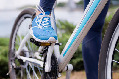 Low section of woman riding bicycle