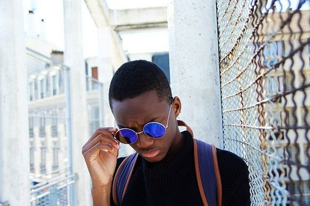 PORTRAIT OF YOUNG MAN STANDING AGAINST WALL