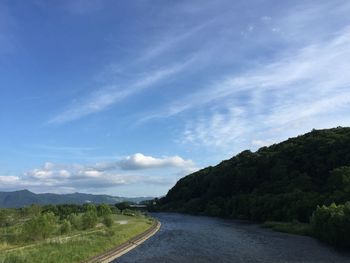 Scenic view of road by mountains against sky