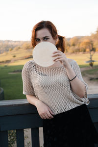 Portrait of young woman standing outdoors